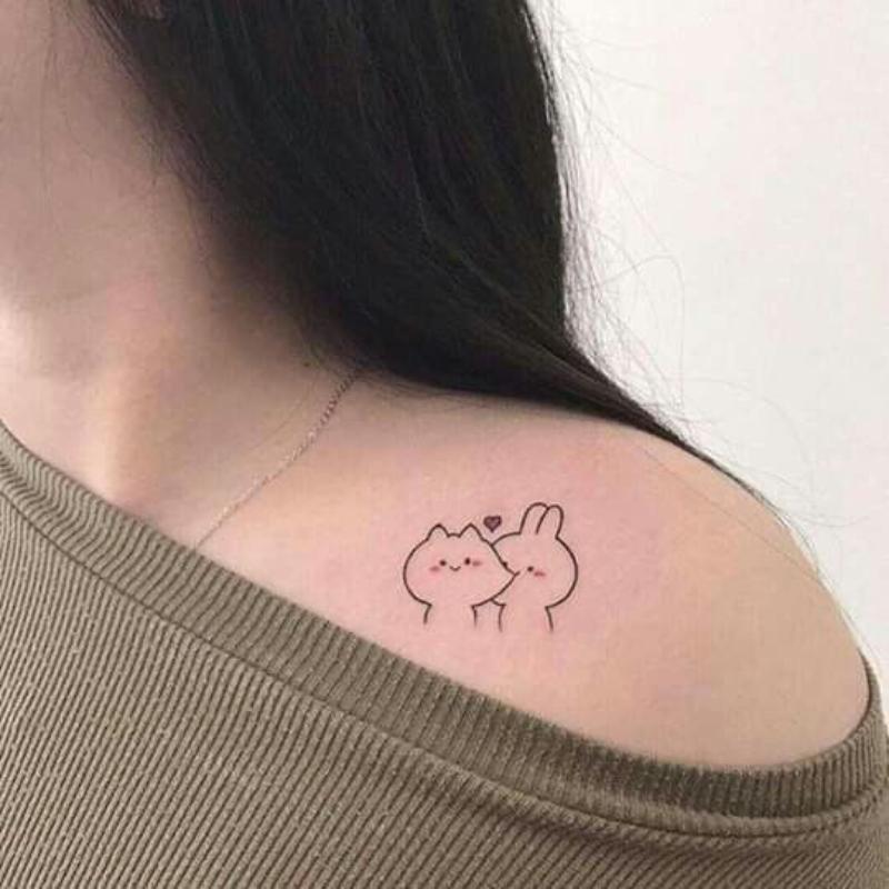 Cartoon cat tattoo on shoulder blade