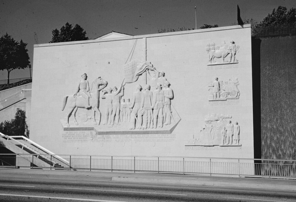 a black and white photo of a building with a mural on it