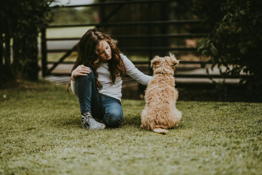 Girl petting a dog on a garden